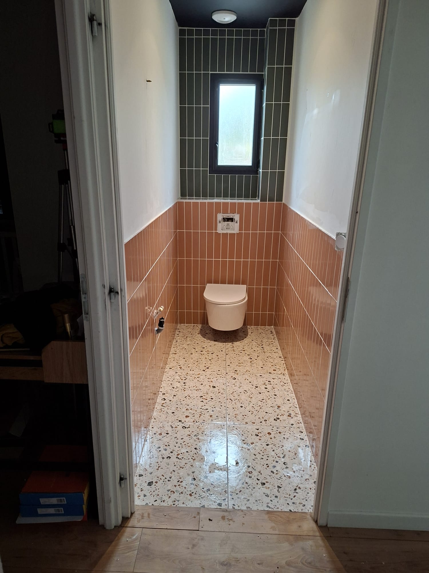 Pose de carrelage dans des toilettes en rénovation