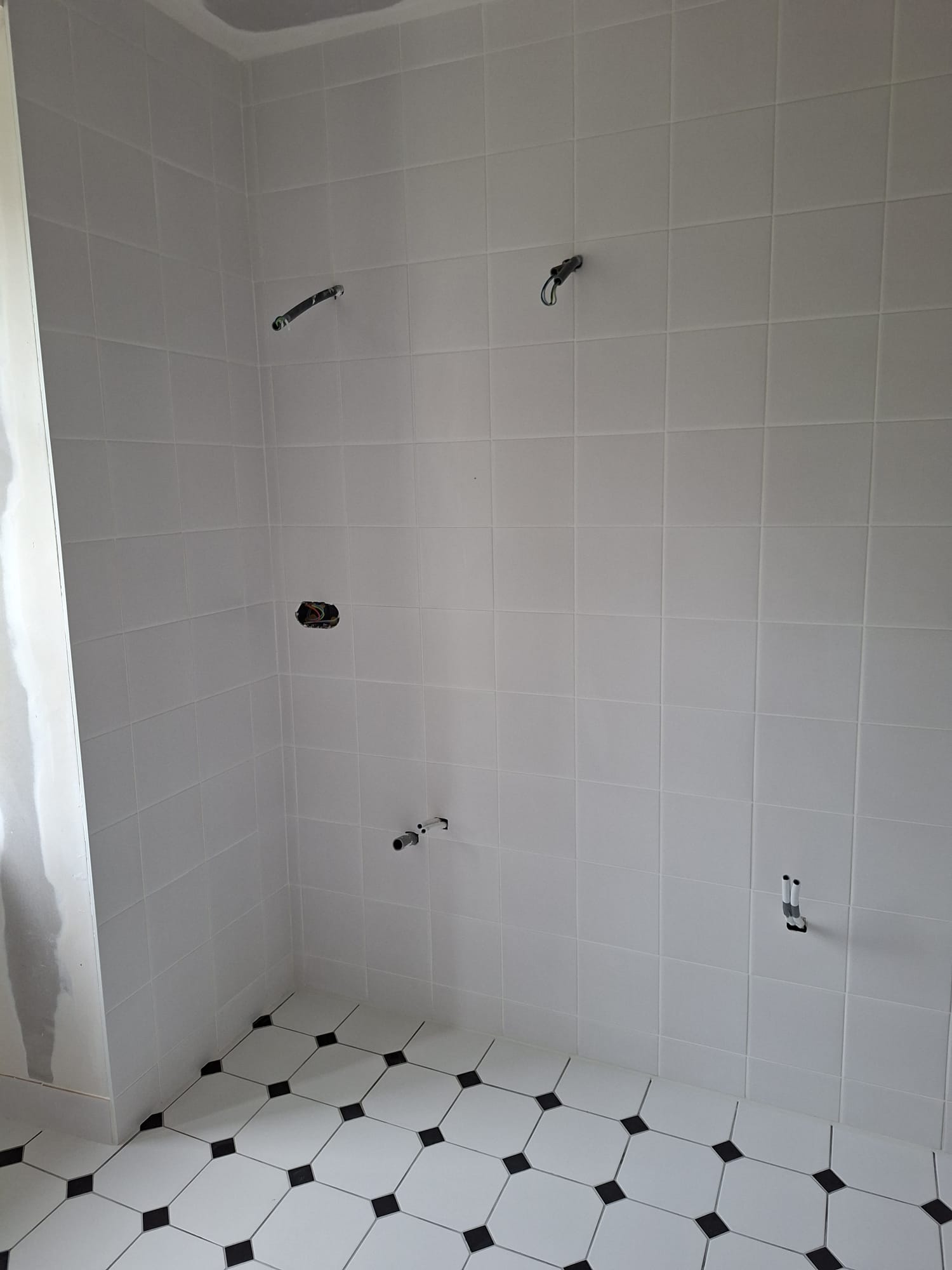 Pose de faïence murale dans une salle de bain